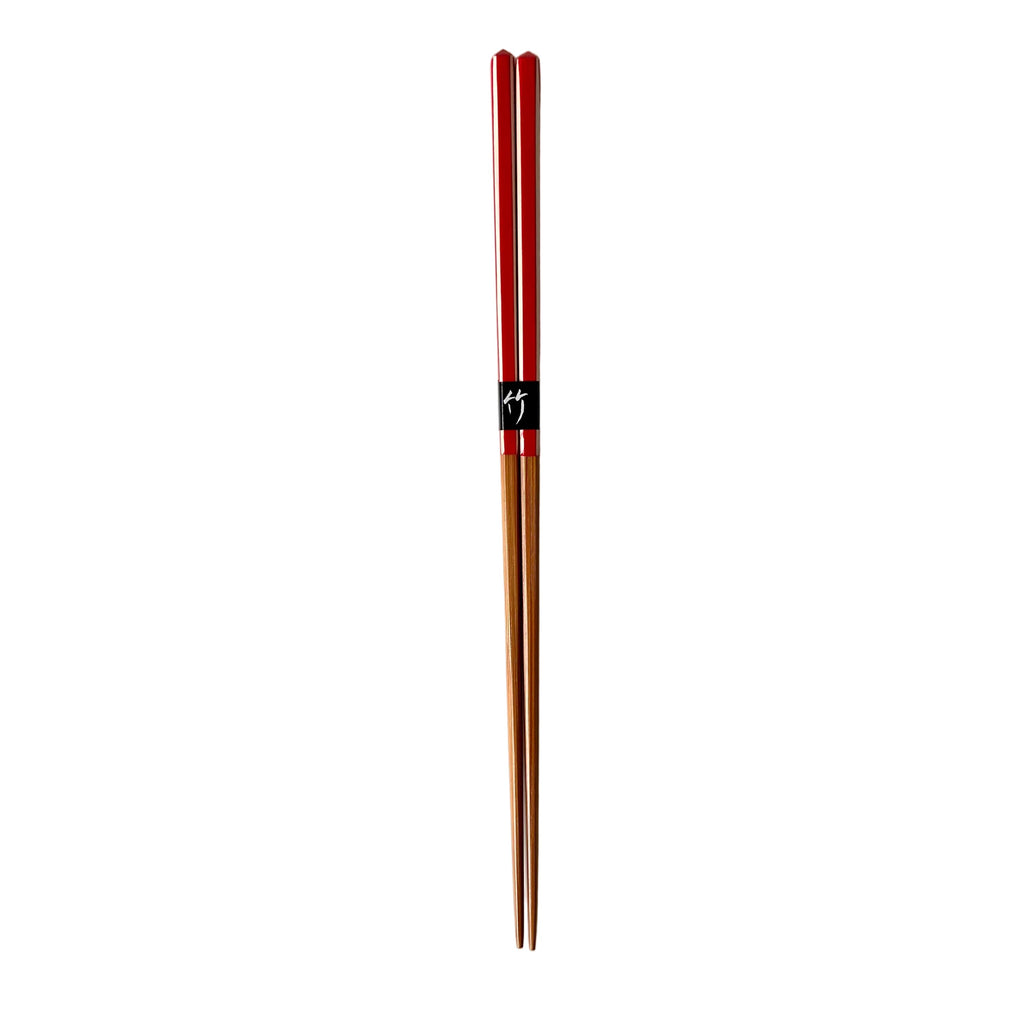 Pair of red and wooden chopsticks on a white background