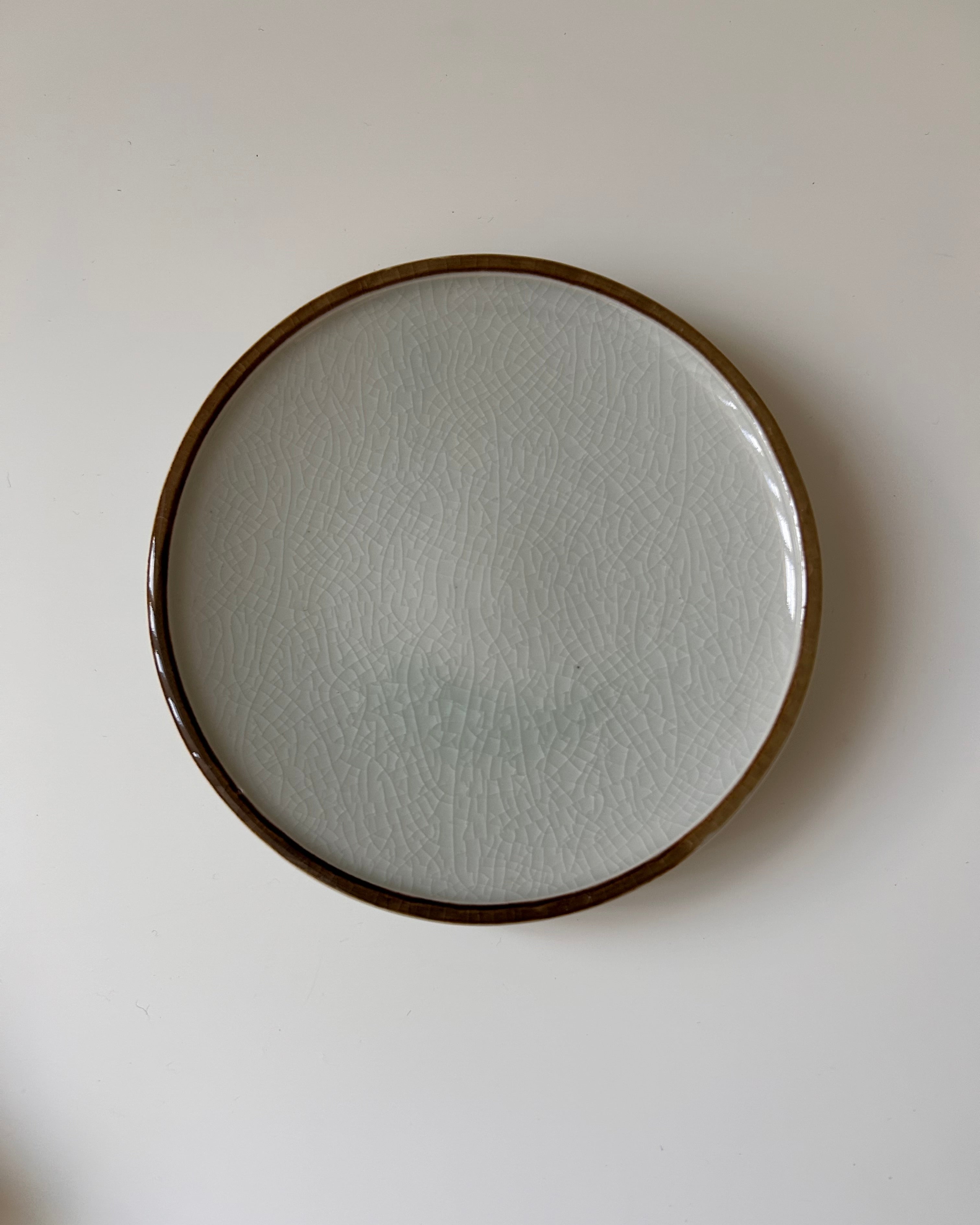 Round ceramic plate with textured surface on a plain background