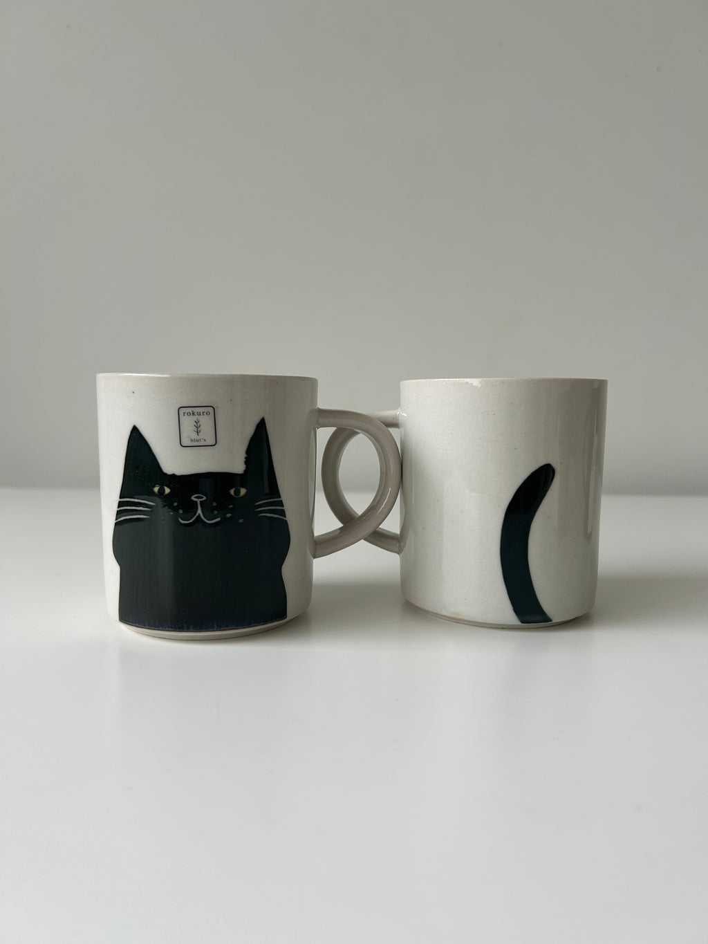 Black cat 's face and tail on mug