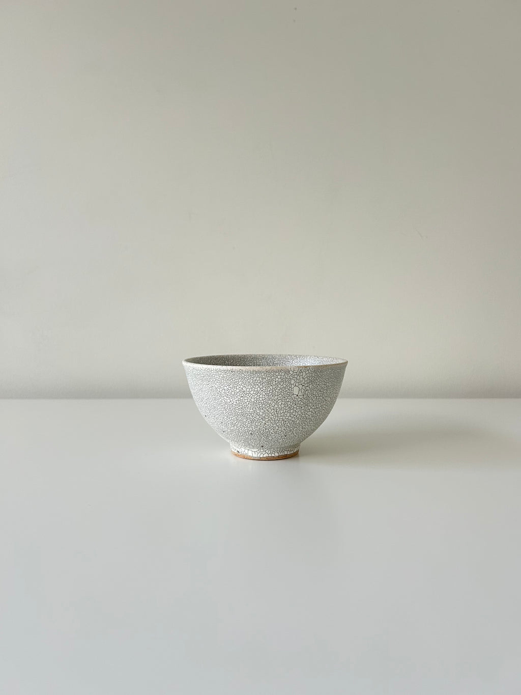 Ceramic bowl with speckled texture on a plain background