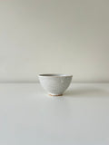 Ceramic bowl with speckled texture on a plain background