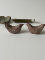 Two ceramic birds chopstick rest on a light gray background