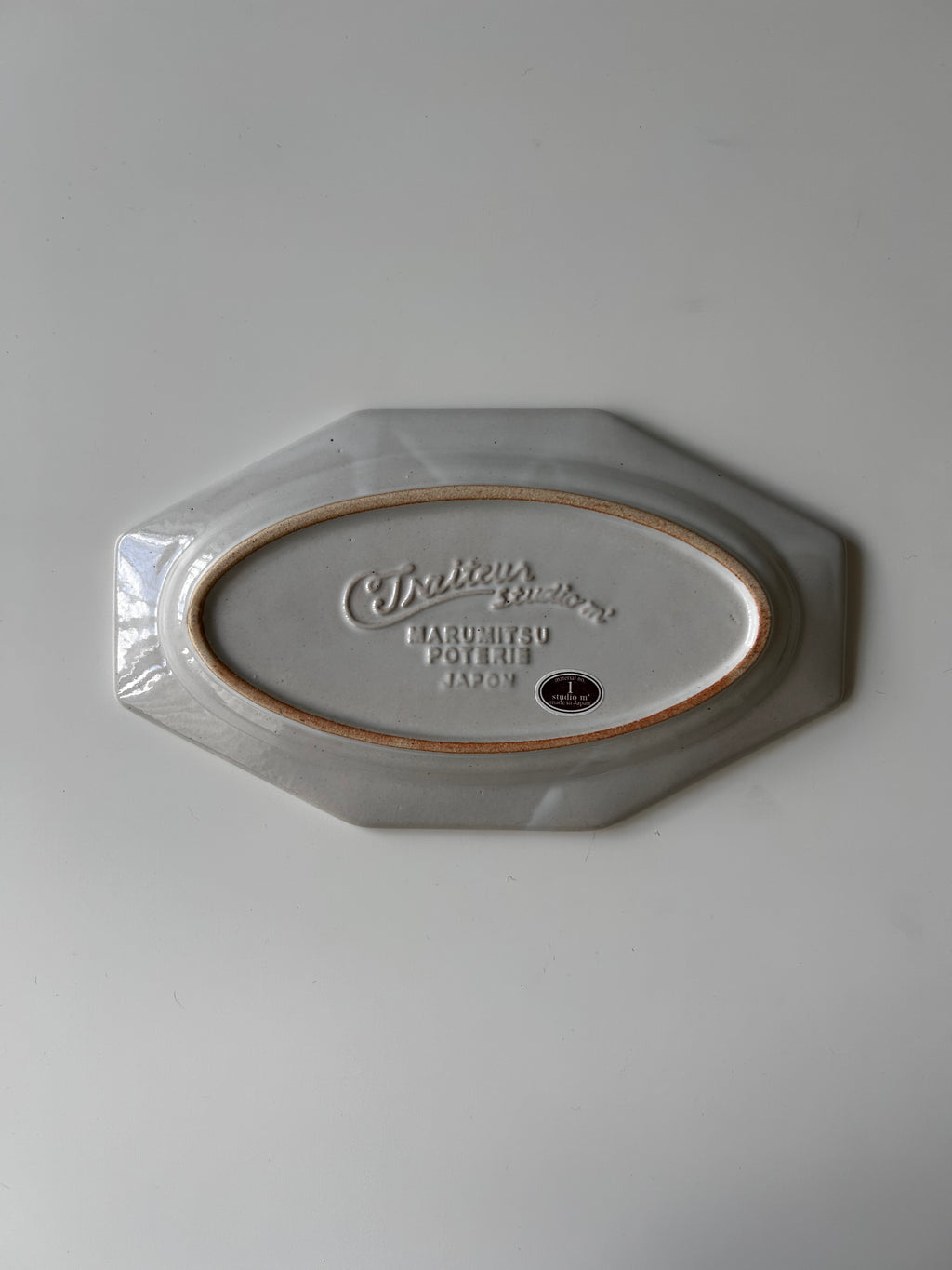 Hexagonal ceramic plate with 'Cuthbertson' branding on a light gray background