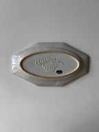 Hexagonal ceramic plate with 'Cuthbertson' branding on a light gray background