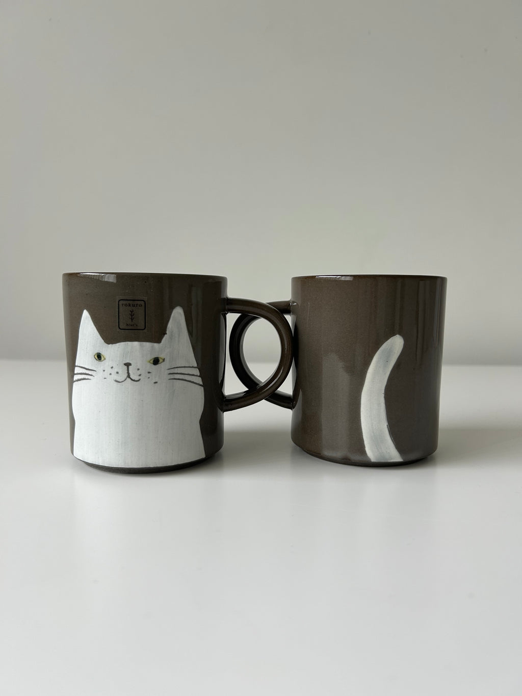 White cat's face and tail on a mug
