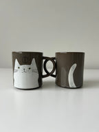 White cat's face and tail on a mug