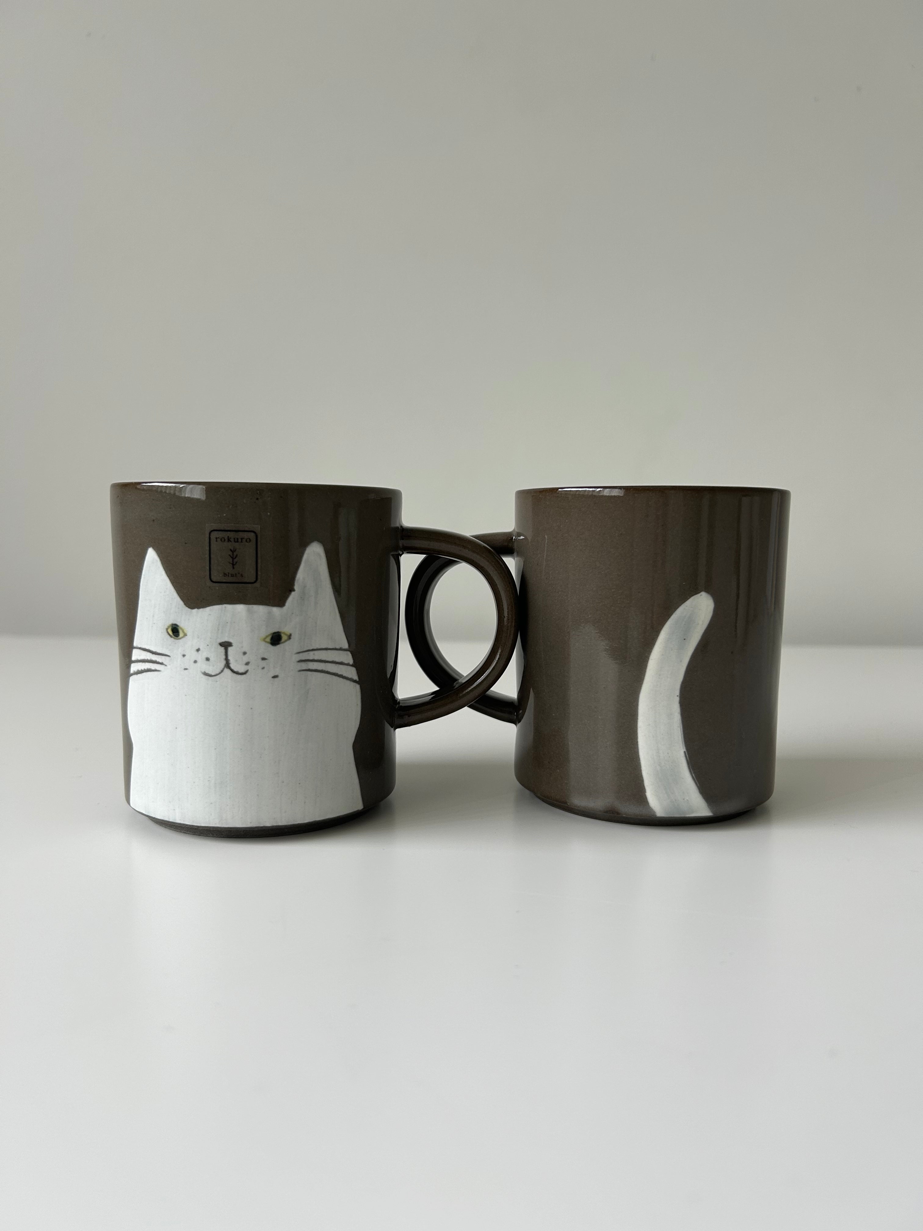 White cat's face and tail on a mug